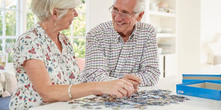 Elderly Couple Doing a Jigsaw Puzzle Together at a Memory Care Facility